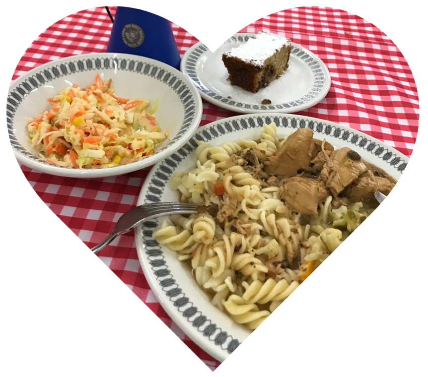 A heart shap showing plates of food on a checked tablecloth